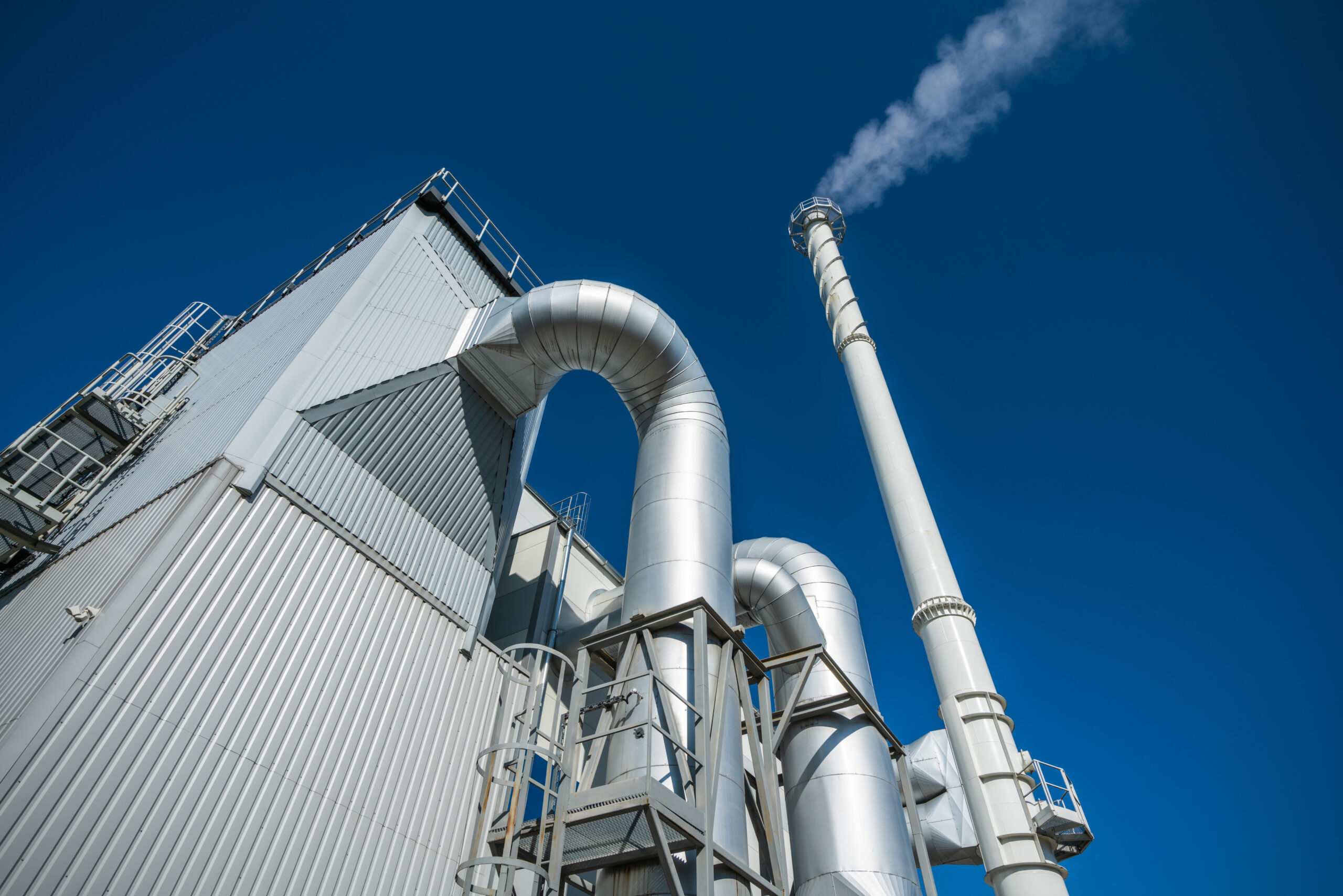 Biofuel boiler chimneys on a blue sky